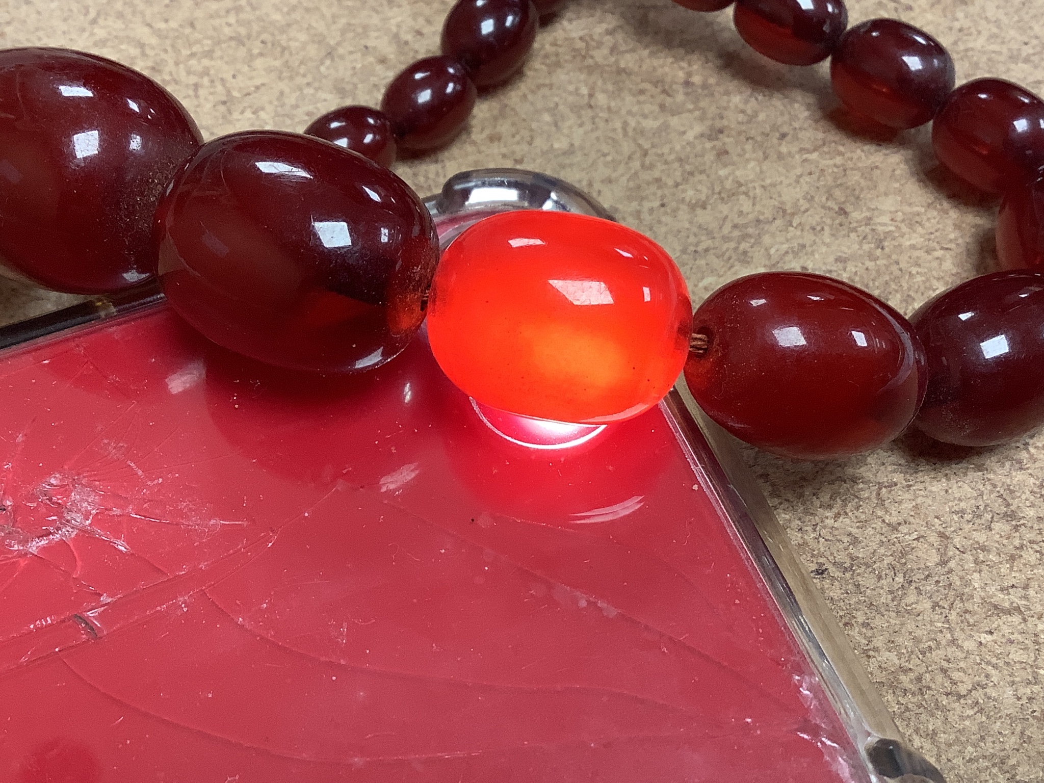 A double strand simulated oval cherry amber bead choker necklace (string broken), 44cm, gross weight 102 grams.